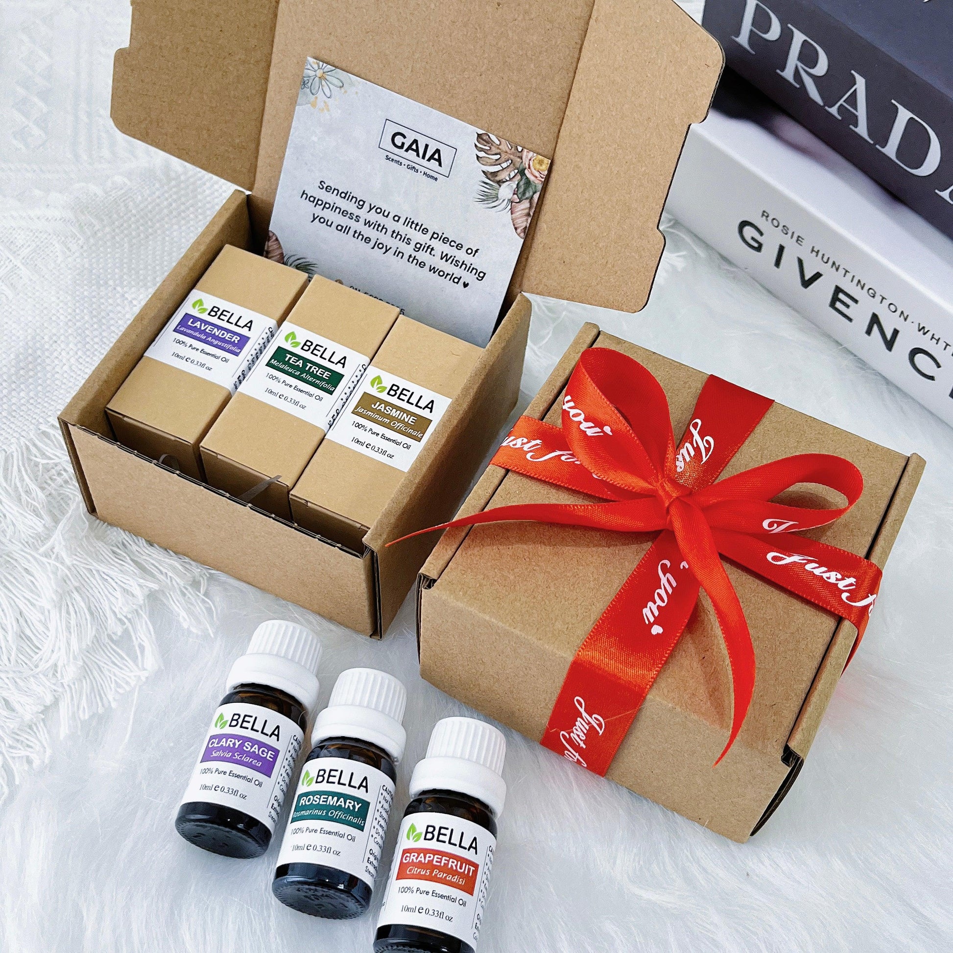 essential oil bundle gift set for health and wellness over a table with gift card and coloured ribbon of choice