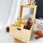 a wider angle shot of the petal and cup gift box with pinecones and orange slices as props next to it over a white and black background