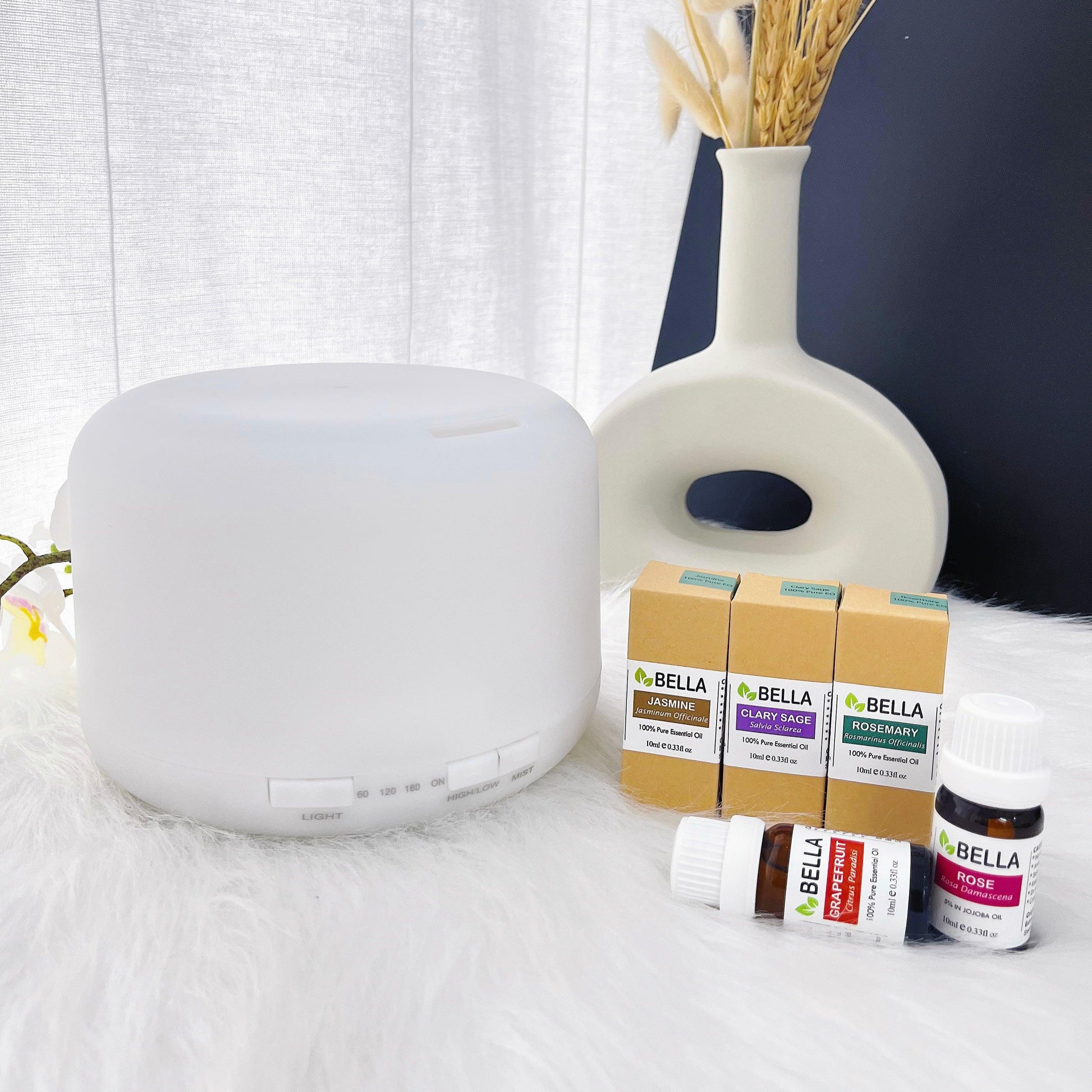 essential oils displayed next to white aromatic 500ml diffuser on a white table