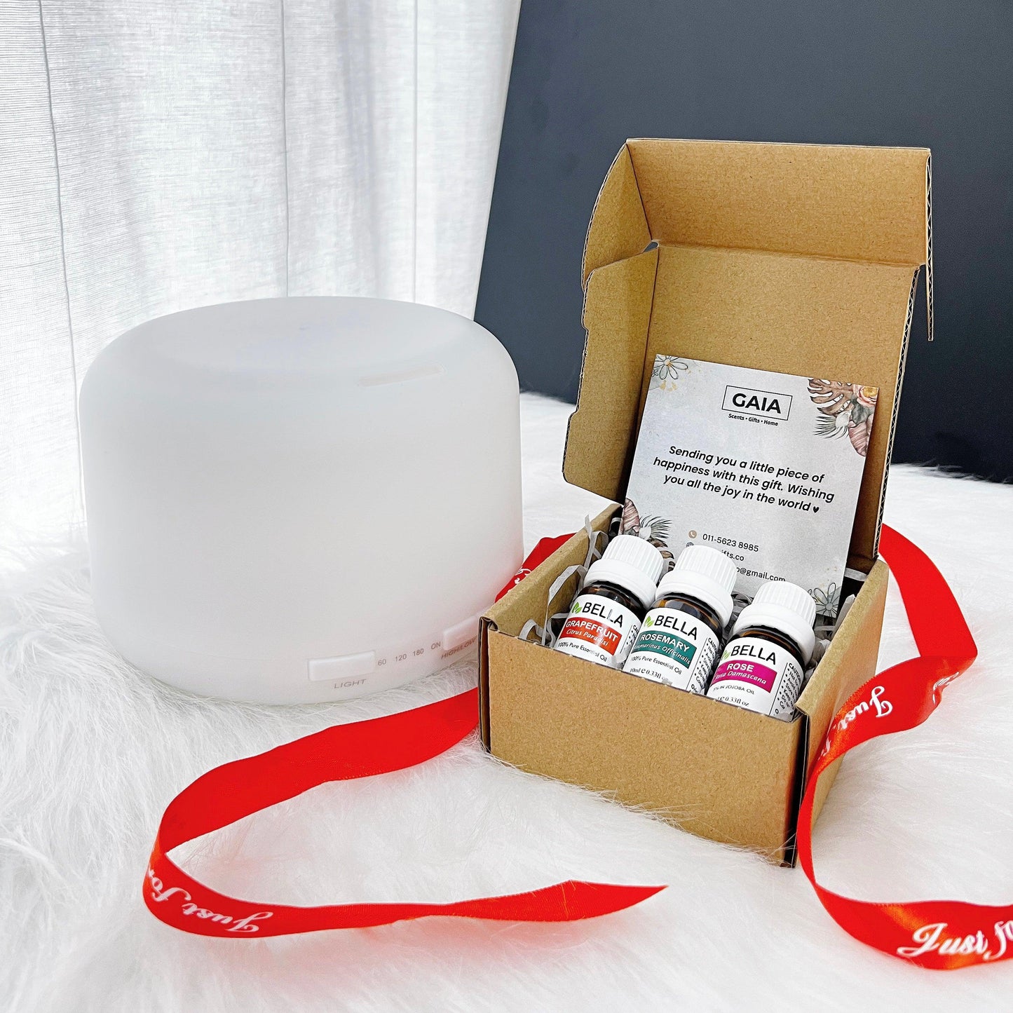 diffuser and opened essential oil gift box with gift card and untied ribbon