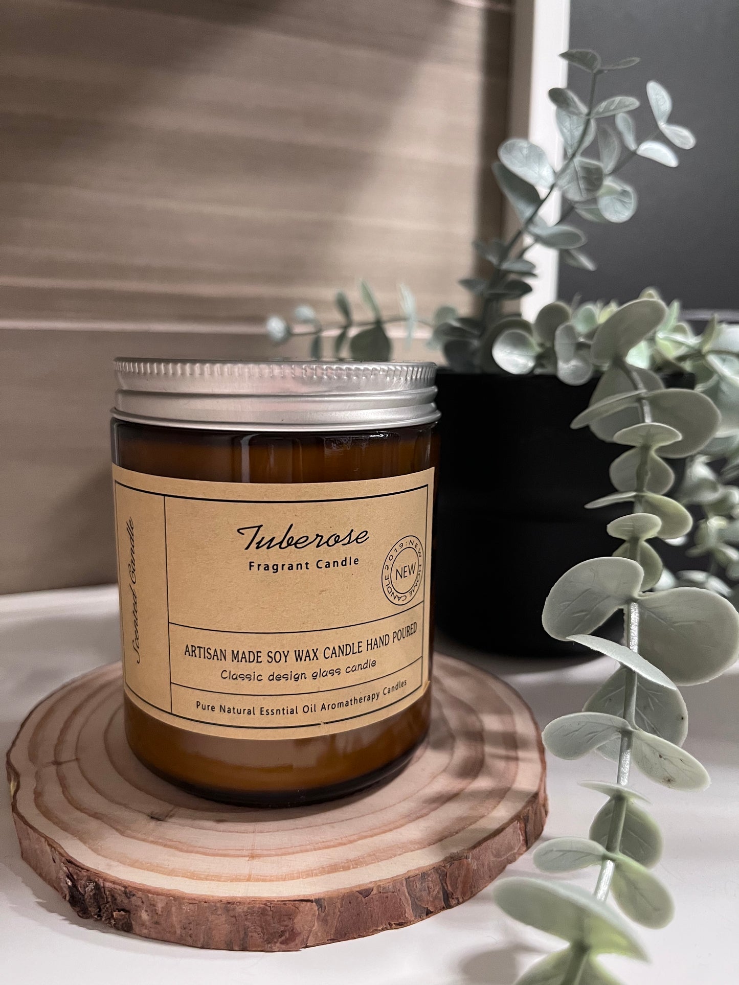 tuberose flavour scented candle over wooden plate on a white table counter